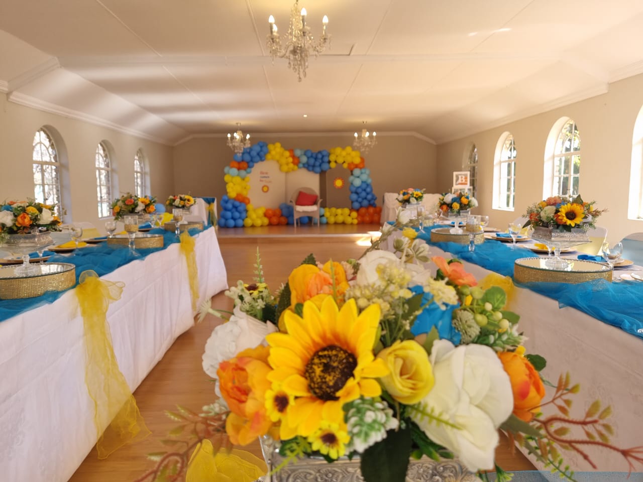 wooden easel welcome sign with here comes the son theme and floral decorations