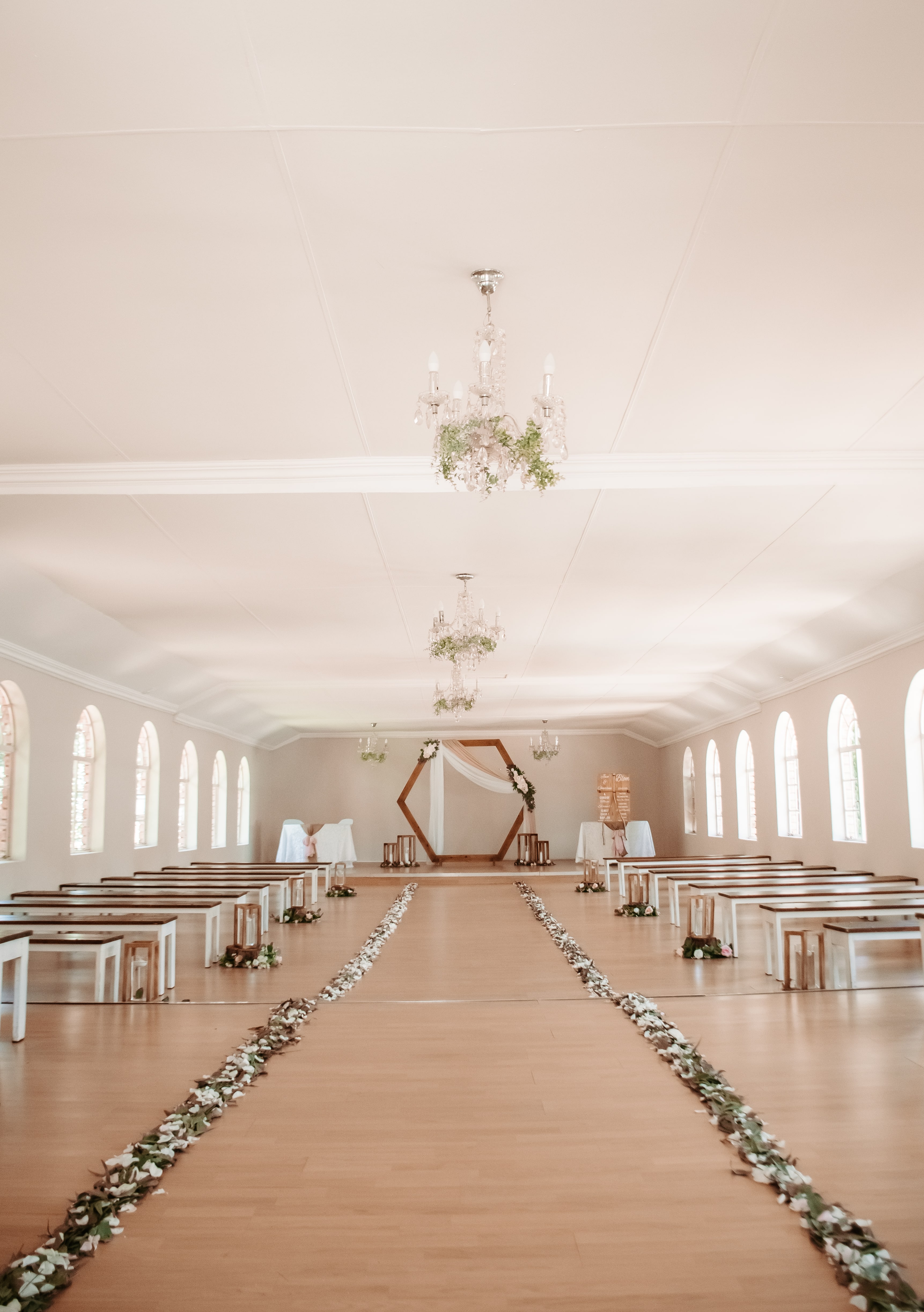 wooden ceremony arch with eucalyptus swag and pink ribbon