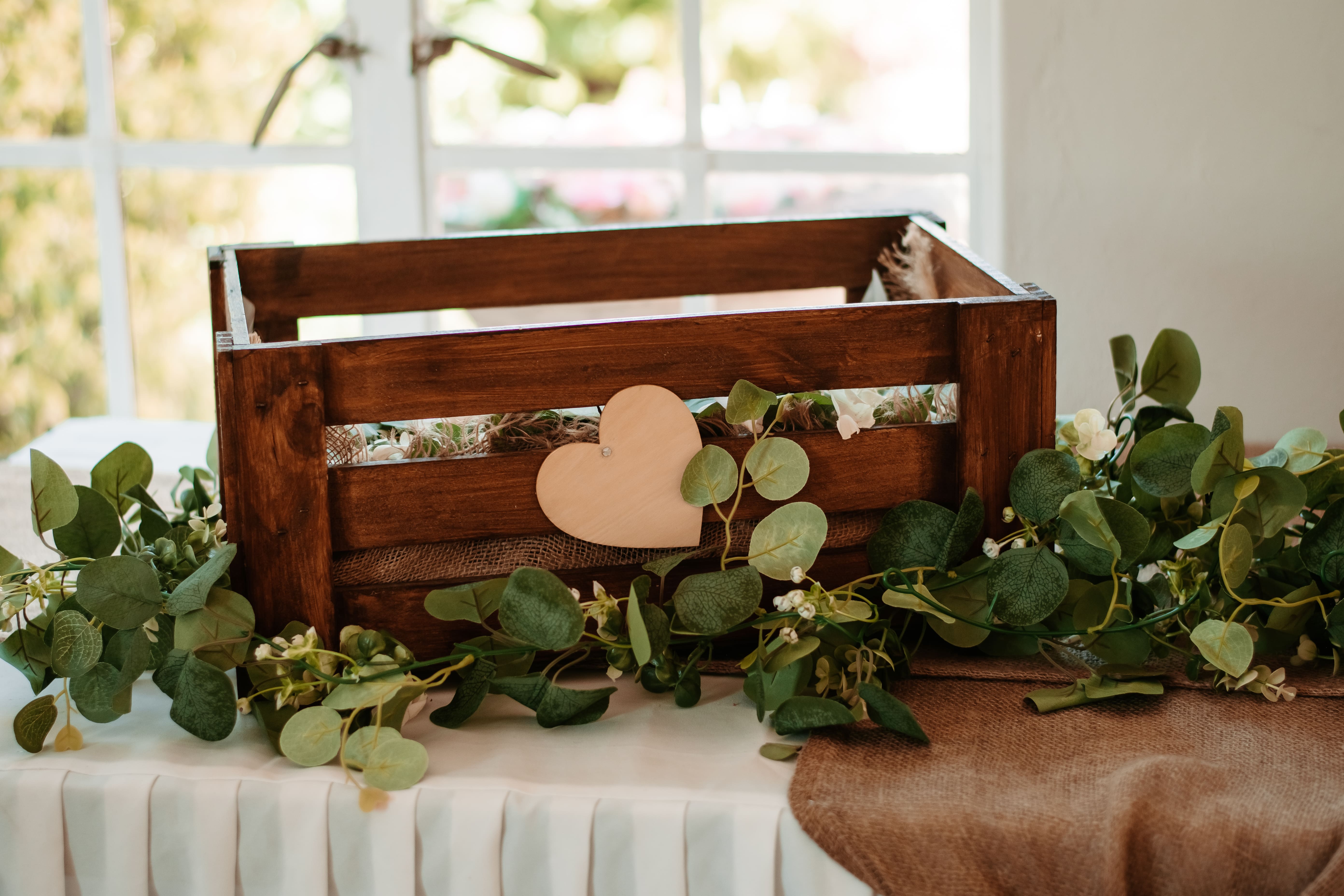 close-up of wooden welcome sign with white roses and eucalyptus